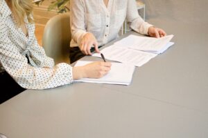 two professional women discuss paperwork